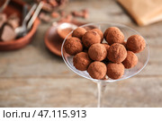 Стакан с вкусными сладкими трюфелями на столе, крупным планом. Стоковое фото, фотограф Pixel_shot / Фотобанк Лори