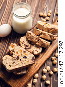 Доска с вкусным печеньем бискотти, молоком и фундуком на коричневом деревянном фоне. Стоковое фото, фотограф Pixel_shot / Фотобанк Лори