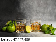 Стаканы рома со льдом, мятой и лаймом на сером фоне. Стоковое фото, фотограф Pixel_shot / Фотобанк Лори