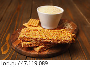 Доска с вкусными козинаками и кунжутом на деревянном фоне. Стоковое фото, фотограф Pixel_shot / Фотобанк Лори