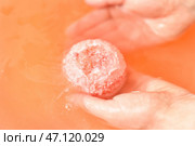 Женщина опускает бомбочку в воду в комнате, крупным планом. Стоковое фото, фотограф Pixel_shot / Фотобанк Лори
