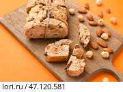 Доска с вкусным печеньем бискотти и орехами на оранжевом фоне. Стоковое фото, фотограф Pixel_shot / Фотобанк Лори