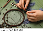 Женщина делает ловец снов на зеленом деревянном фоне, крупным планом. Стоковое фото, фотограф Pixel_shot / Фотобанк Лори