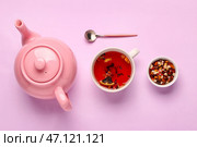 Керамический заварной чайник с чашкой чая и сухофруктами на фоне лилового цвета. Стоковое фото, фотограф Pixel_shot / Фотобанк Лори