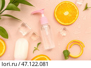 Косметические бутылки с апельсиновыми ломтиками, льдом и мятой на бежевом фоне. Стоковое фото, фотограф Pixel_shot / Фотобанк Лори