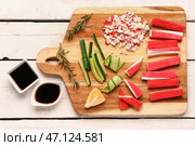 Доска с вкусными крабовыми палочками и соусами на светлом деревянном фоне. Стоковое фото, фотограф Pixel_shot / Фотобанк Лори