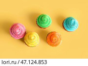 Вкусные красочные капкейки на желтом фоне. Стоковое фото, фотограф Pixel_shot / Фотобанк Лори