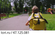 Boy schoolboy goes to school with a backpack. Стоковое видео, видеограф Igor Skripachev / Фотобанк Лори