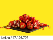 Сланцевая доска с вкусным чурчхела и гранатом на желтом фоне. Стоковое фото, фотограф Pixel_shot / Фотобанк Лори