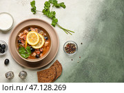 Миска вкусного супа Ходжподж со сметаной и хлебом на грунтовом фоне. Стоковое фото, фотограф Pixel_shot / Фотобанк Лори