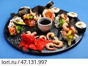 Доска с вкусными суши-конусами, соевым соусом, имбирем и креветками на цветном фоне, крупный план. Стоковое фото, фотограф Pixel_shot / Фотобанк Лори