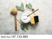 Композиция с миской соды, чистящей щеткой, губкой и ветками эвкалипта на грунтовом фоне. Стоковое фото, фотограф Pixel_shot / Фотобанк Лори