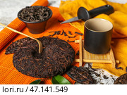Сухой прессованный чай пуэр, чашаку и чашка на столе, крупным планом. Стоковое фото, фотограф Pixel_shot / Фотобанк Лори