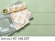 Горчичники с полотенцем, миской с водой и таблетками на зеленом деревянном фоне. Стоковое фото, фотограф Pixel_shot / Фотобанк Лори