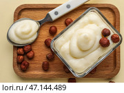 Деревянная доска с вкусным ванильным пудингом и фундуком на цветном фоне, крупным планом. Стоковое фото, фотограф Pixel_shot / Фотобанк Лори