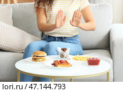 Молодая афроамериканка отказывается от нездоровой пищи дома. Концепция диеты. Стоковое фото, фотограф Pixel_shot / Фотобанк Лори