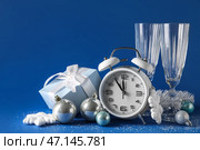 Белые новогодние часы, очки, украшения и подарочная коробка на синем фоне. Стоковое фото, фотограф Pixel_shot / Фотобанк Лори