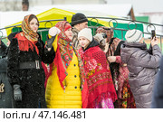 Женщины с повязанными Павловопосадскими яркими цветными платками на головах. Празднование Масленицы на территории Кафедрального собора в честь Преображения Господня. Бердск, Новосибирская область, Западная Сибирь, Россия. Редакционное фото, фотограф Евгений Мухортов / Фотобанк Лори