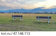 A scenic landscape with benches overlooking majestic mountains, perfect for relaxation. Стоковое видео, видеограф Vladimir Vintonjak / Фотобанк Лори