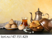 Вкусные восточные сладости и чай с тасбихом на столе. Стоковое фото, фотограф Pixel_shot / Фотобанк Лори