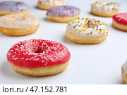 Сладкие вкусные пончики на белом фоне. Стоковое фото, фотограф Pixel_shot / Фотобанк Лори