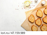 Деревянная доска с вкусными поджаренными хлебцами на светлом фоне. Стоковое фото, фотограф Pixel_shot / Фотобанк Лори