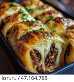 A delicious baked dish with a meat filling wrapped in thin dough and topped with melted golden cheese. The juicy, well-seasoned minced meat filling is visible through the stretchy layers of melted cheese. The dish is generously decorated with fresh herbs, which gives it additional brightness. The baked crust has an appetizing ruddy color, and the stringy cheese makes the texture especially attractive. This dish is reminiscent of lasagne, meat rolls or baked cannelloni, ideal for a cozy home dinner. Стоковое AI-изображение, AI-художник Анна Кривицкая / Фотобанк Лори