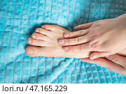 Woman giving herself foot massage, corns and calluses on feet, dry skin on legs. Стоковое фото, фотограф Станислав Тарко / Фотобанк Лори
