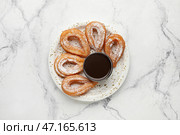 Тарелка с вкусными чуррос и соусом из расплавленного шоколада на светлом фоне. Стоковое фото, фотограф Pixel_shot / Фотобанк Лори