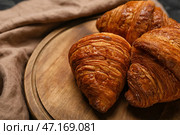 Доска с вкусными круассанами на салфетке, крупным планом. Стоковое фото, фотограф Pixel_shot / Фотобанк Лори