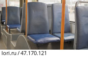 Empty blue seats and orange handrails in public transport in a trolleybus. Стоковое видео, видеограф Дмитрий Нечаев / Фотобанк Лори
