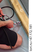 Rigger securing carabiner to wooden beam using swivel ring. Стоковое фото, фотограф Юрий Поздников / Фотобанк Лори