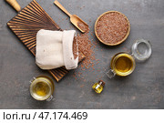 Банки с льняным маслом и деревянная чаша с семенами на сером фоне. Стоковое фото, фотограф Pixel_shot / Фотобанк Лори