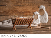 Мангер с ребенком и игрушечной овечкой на деревянном фоне. Концепция рождественской истории. Стоковое фото, фотограф Pixel_shot / Фотобанк Лори