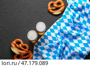Флаг Баварии, кружки с пивом и брецели на черном фоне. Стоковое фото, фотограф Pixel_shot / Фотобанк Лори