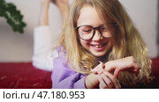 Focused child using smart watch for homework reminders, time management, and study assistance. Concept of digital tools improving education, student productivity, and smart learning solutions. Стоковое видео, видеограф Енваев Андрей / Фотобанк Лори