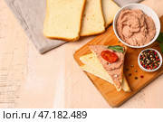 Доска с миской вкусного паштета, бутербродами и перцем на светлом деревянном фоне. Стоковое фото, фотограф Pixel_shot / Фотобанк Лори