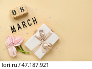 Композиция с красивыми цветами ранункулюса, кубическим календарем и подарком к женскому дню на цветном фоне. Стоковое фото, фотограф Pixel_shot / Фотобанк Лори
