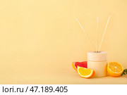 Рассеиватель из тростника с цитрусовыми на цветном фоне. Стоковое фото, фотограф Pixel_shot / Фотобанк Лори