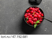 Чашка с свежими малинами и мятой на черном фоне. Стоковое фото, фотограф Pixel_shot / Фотобанк Лори