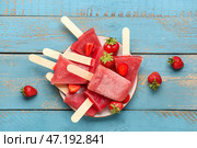 Тарелка с милыми клубничными морожеными-пломбиром на голубом деревянном фоне. Стоковое фото, фотограф Pixel_shot / Фотобанк Лори