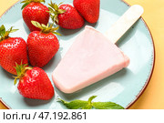 Тарелка с сладким клубничным мороженым-пломбиром на жёлтом фоне. Стоковое фото, фотограф Pixel_shot / Фотобанк Лори