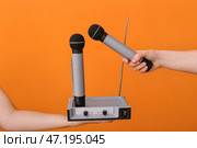 Женские руки с современными микрофонами и аудиосистемой на цветном фоне. Стоковое фото, фотограф Pixel_shot / Фотобанк Лори