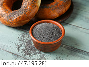 Чаша с маком и вкусными рогаликами на цветном деревянном фоне. Стоковое фото, фотограф Pixel_shot / Фотобанк Лори