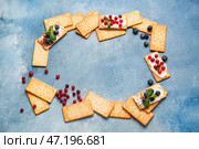 Рамка из вкусных крекеров с ягодами на цветном фоне. Стоковое фото, фотограф Pixel_shot / Фотобанк Лори