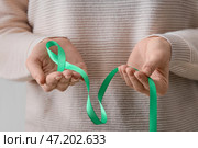 Женщина с зеленой лентой, крупным планом. Концепция митохондриальных заболеваний и рака почки. Стоковое фото, фотограф Pixel_shot / Фотобанк Лори