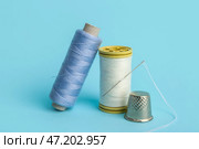 Катушки ниток с иглой и наперстком на цветном фоне. Стоковое фото, фотограф Pixel_shot / Фотобанк Лори