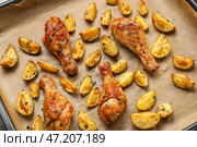 Противень с вкусным печеным картофелем и куриными ножками, крупным планом. Стоковое фото, фотограф Pixel_shot / Фотобанк Лори
