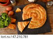 Грифельная доска с вкусным сырным пирогом и ингредиентами на деревянном фоне. Стоковое фото, фотограф Pixel_shot / Фотобанк Лори