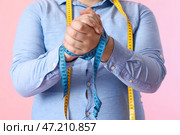 Молодой толстяк с рулеткой на розовом фоне, крупным планом. Стоковое фото, фотограф Pixel_shot / Фотобанк Лори